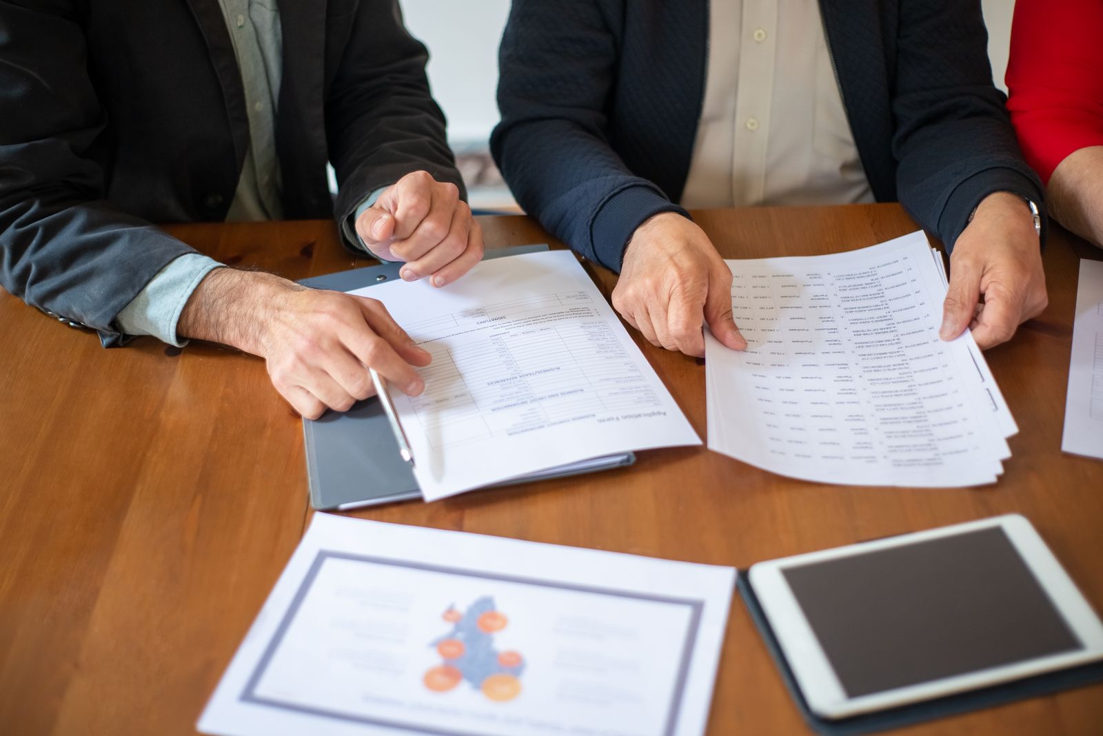 Profesionales revisando informes y documentación empresarial sobre una mesa de trabajo